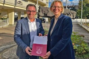 Rlp-Innenstaatssekretärin Simone Schneider übergibt VG-Bürgermeister Marcel Caspers einen Förderbescheid aus dem Investitionsstock.
