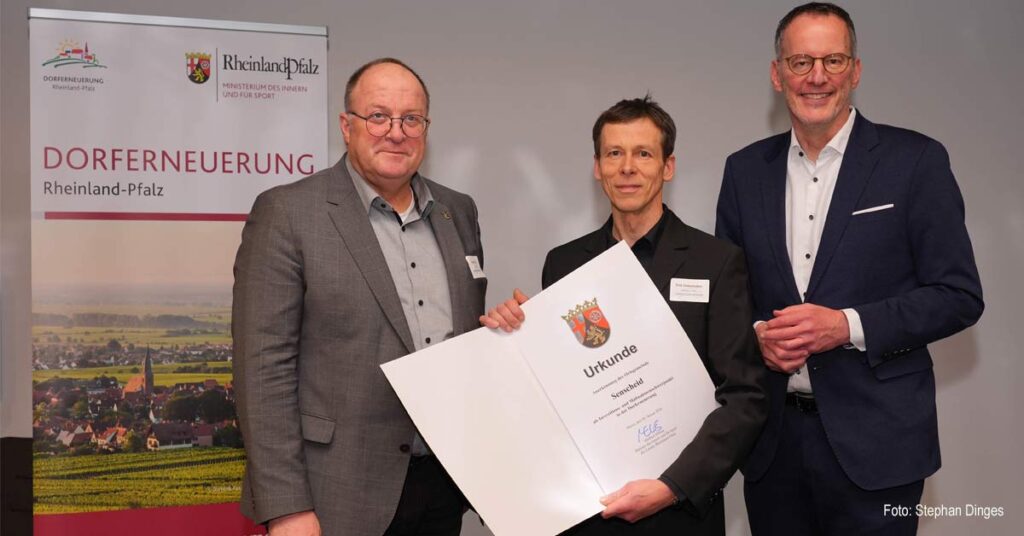 Das Dorf Senscheid in der Verbandsgemeinde Adenau wird neue Schwerpunktgemeinde der Dorferneuerung: Innenminister Michael Ebling (r.) zeichnet das 78-Einwohner-Dorf in der VG Adenau aus. Dirk Ueberhofen (m.), der Bürgermeister der Ortsgemeinde und Guido Nisius, Bürgermeister der Verbandsgemeinde nehmen die Urkunde entgegen.