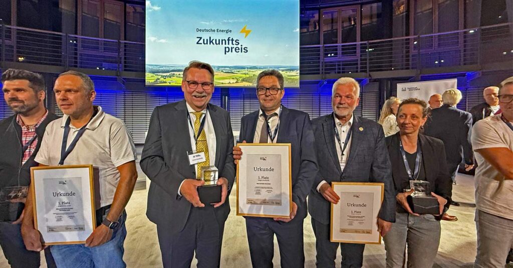 „Marienthal gewinnt bundesweiten Energiepreis“. Gisbert Knichwitz (3.v.l.) und Rolf Schmitt (4.v.l.) nehmen den Preis in Berlin stellvertretend entgegen.